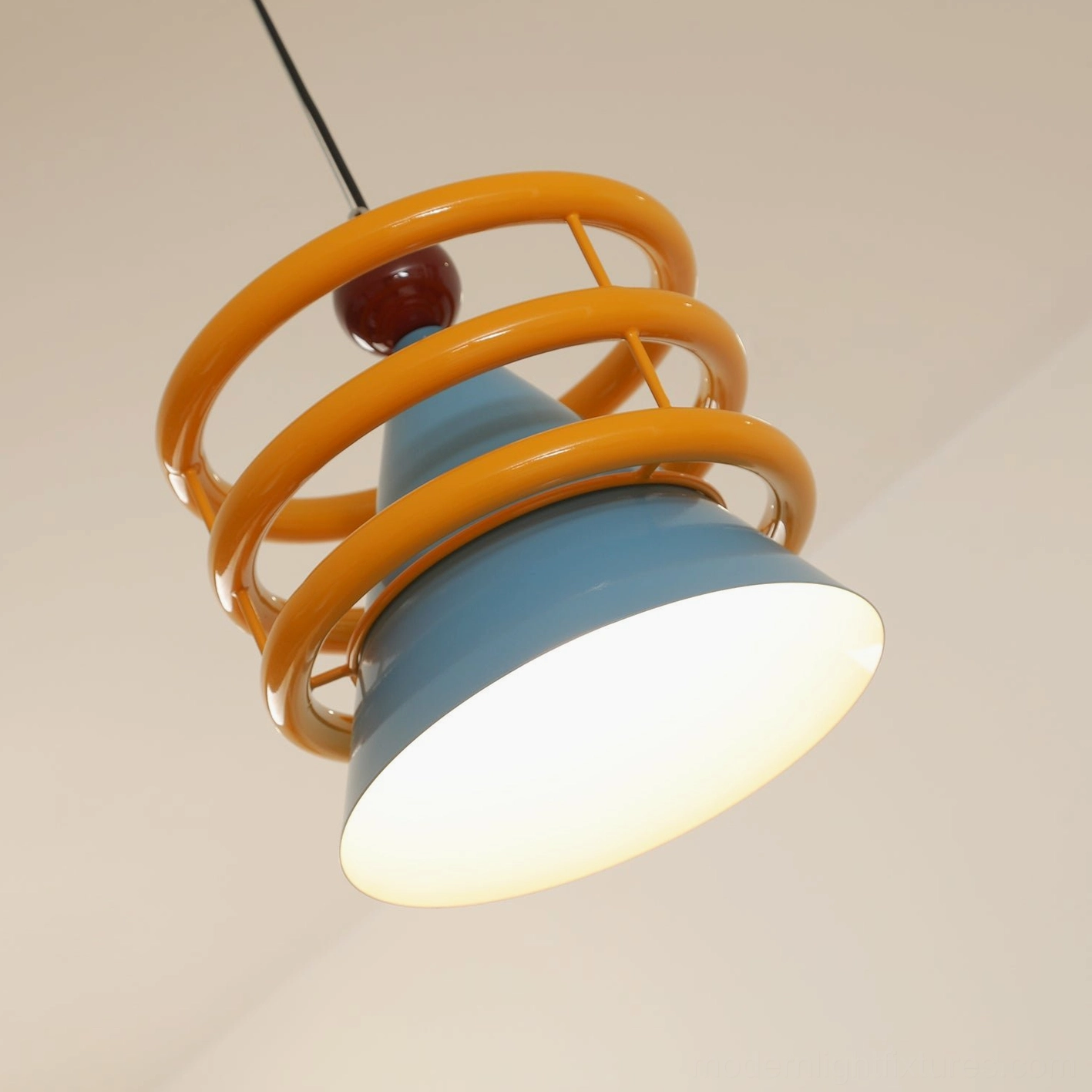 Close-up detail of Sowden pendant light showing guard rings, metal cone shade and warm sphere finial accent