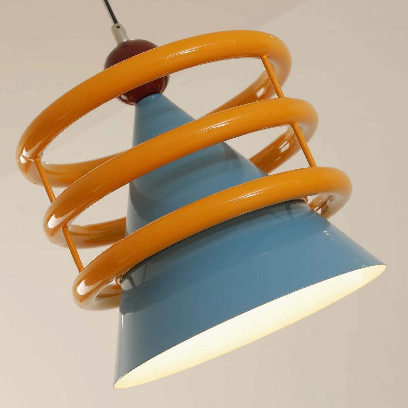 Sowden cone pendant light illuminated detail view, showing interior glow and geometric metal construction