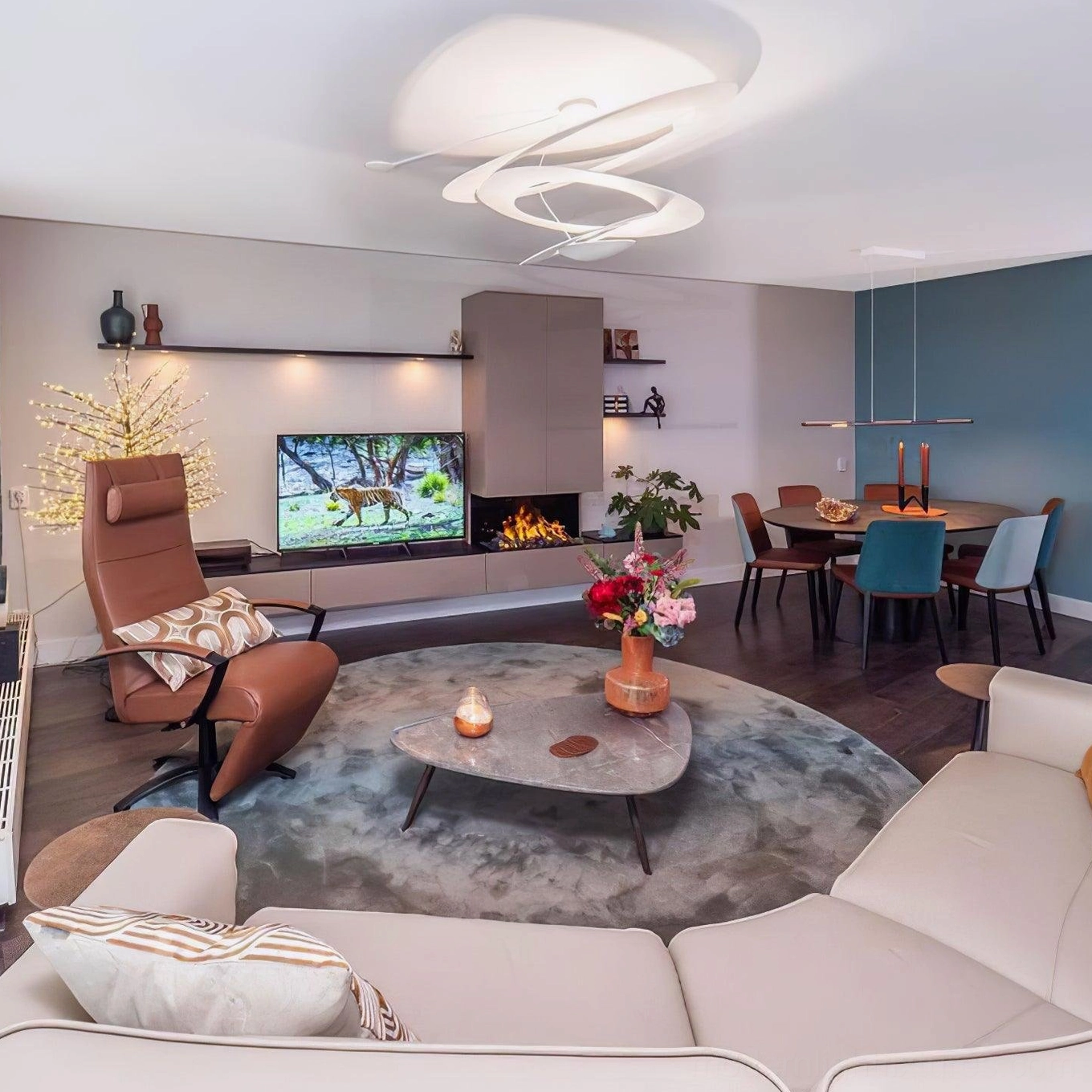 Spiral LED pendant light overhead view in open-plan living and dining area, sleek matte white contemporary design