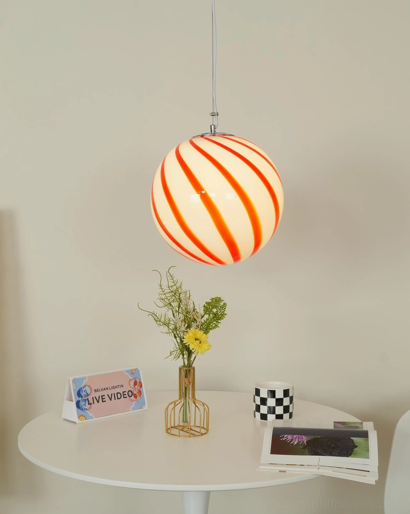 Spiral stripe glass pendant light fixture, front view showcasing the vibrant color saturation and spherical globe design