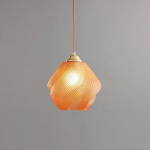 Spirvia twisted glass pendant lamp glowing from within - close-up shot on gray background highlighting swirled frosted glass and brass fixture