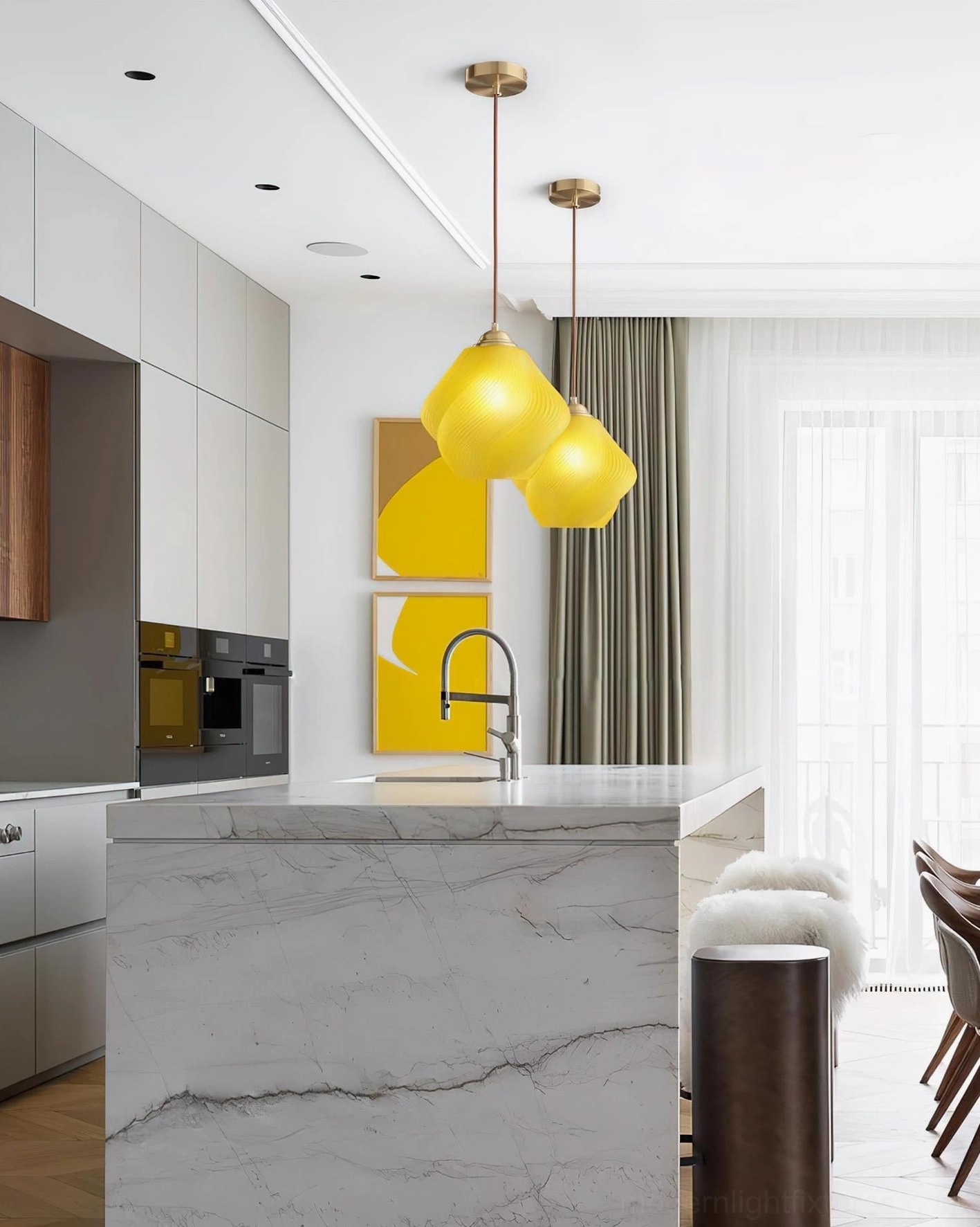 Dual Spirvia yellow twisted glass pendant lights in modern kitchen dining area - interior design installation above marble island