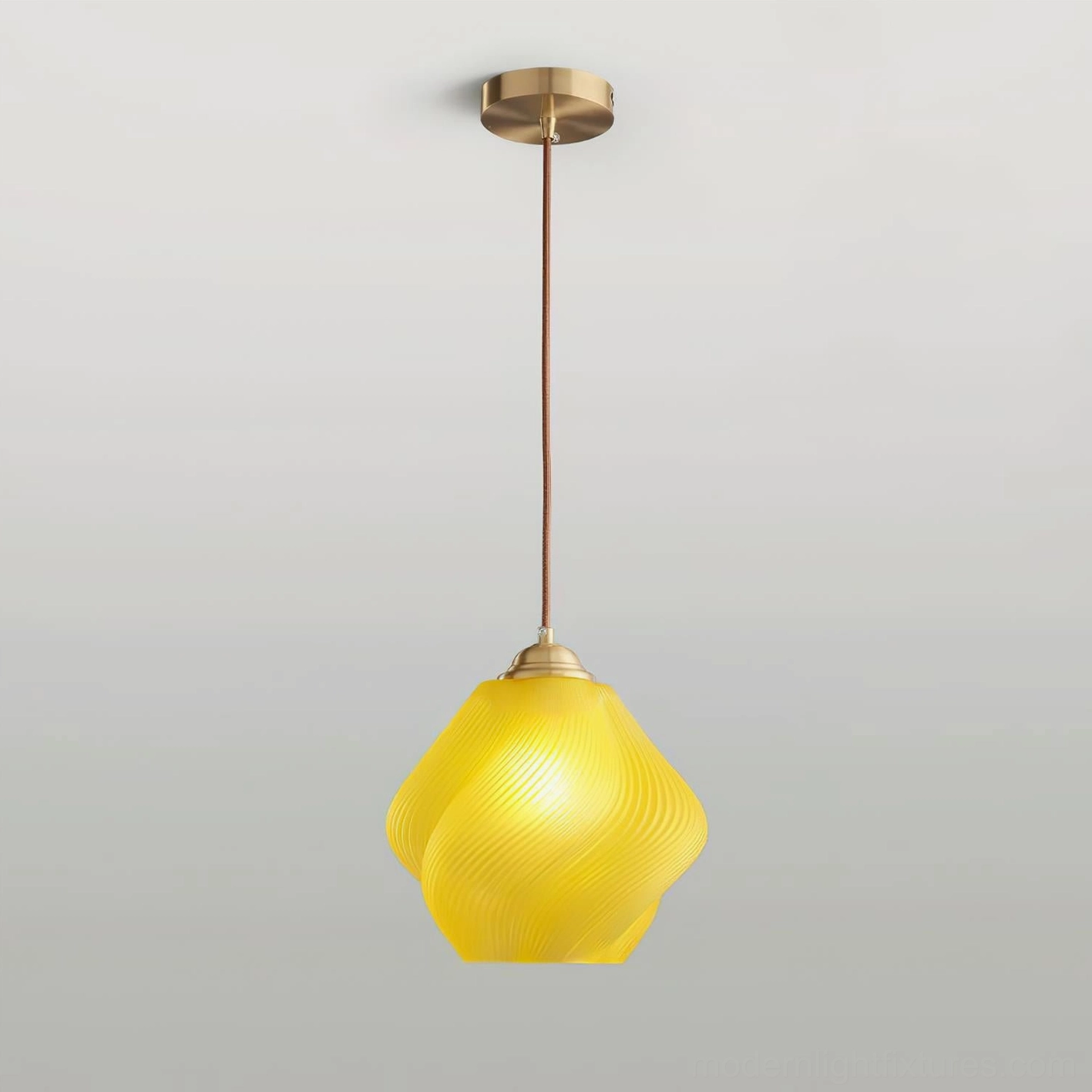 Spirvia yellow twisted glass pendant light - overhead view showing brass ceiling canopy and full suspension setup with glowing glass shade