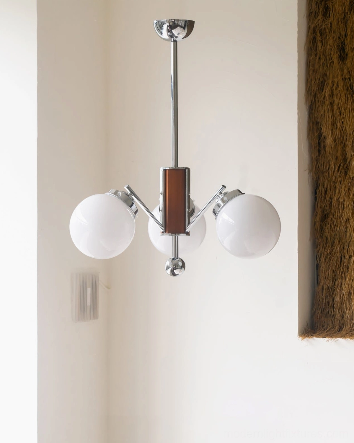 3-head sputnik chandelier in residential interior, unlit frosted glass shades, chrome metal and walnut wood accents