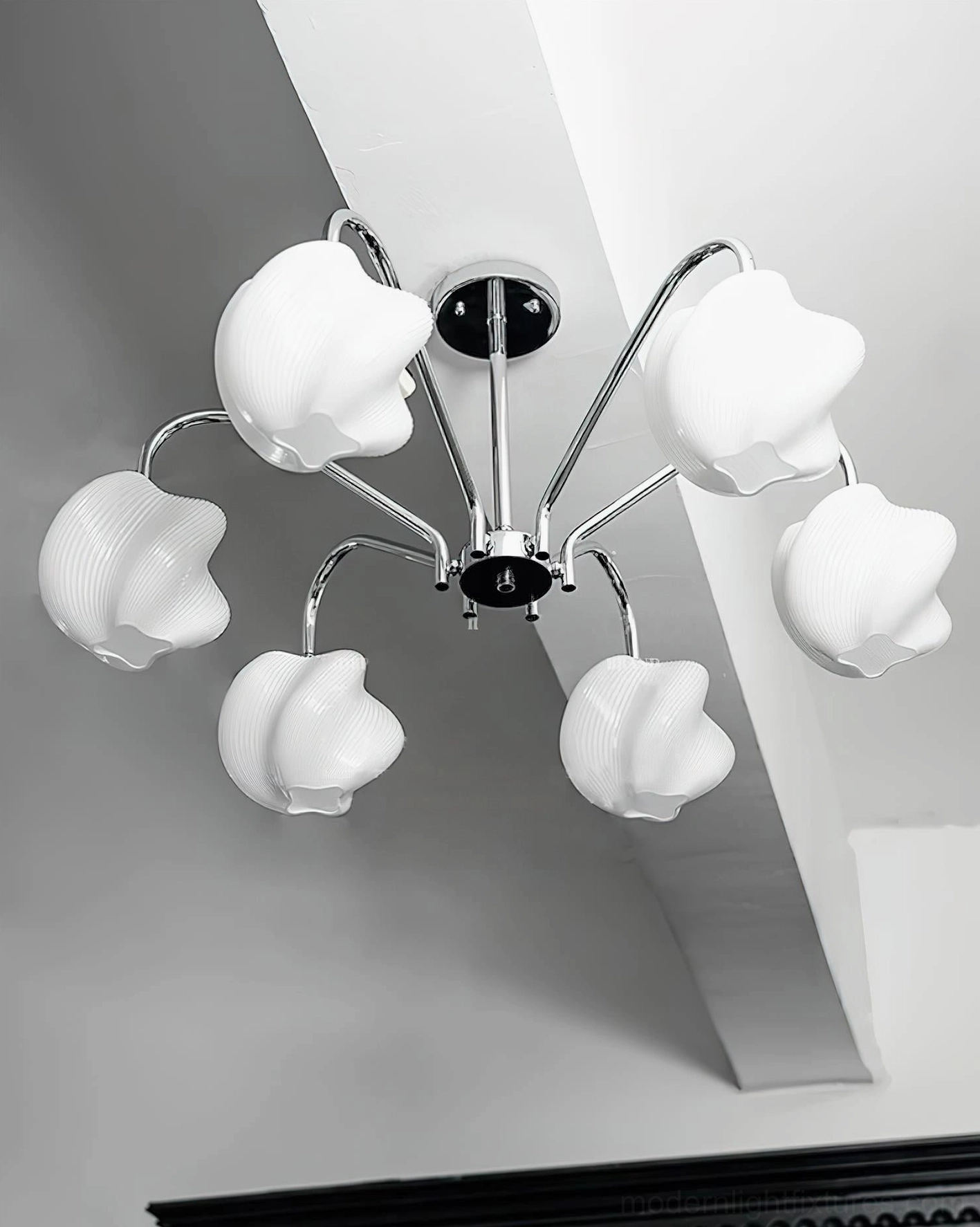 Bottom view of 6-head sputnik chandelier showcasing petal-shaped milky glass shades and geometric chrome arm design against minimalist ceiling