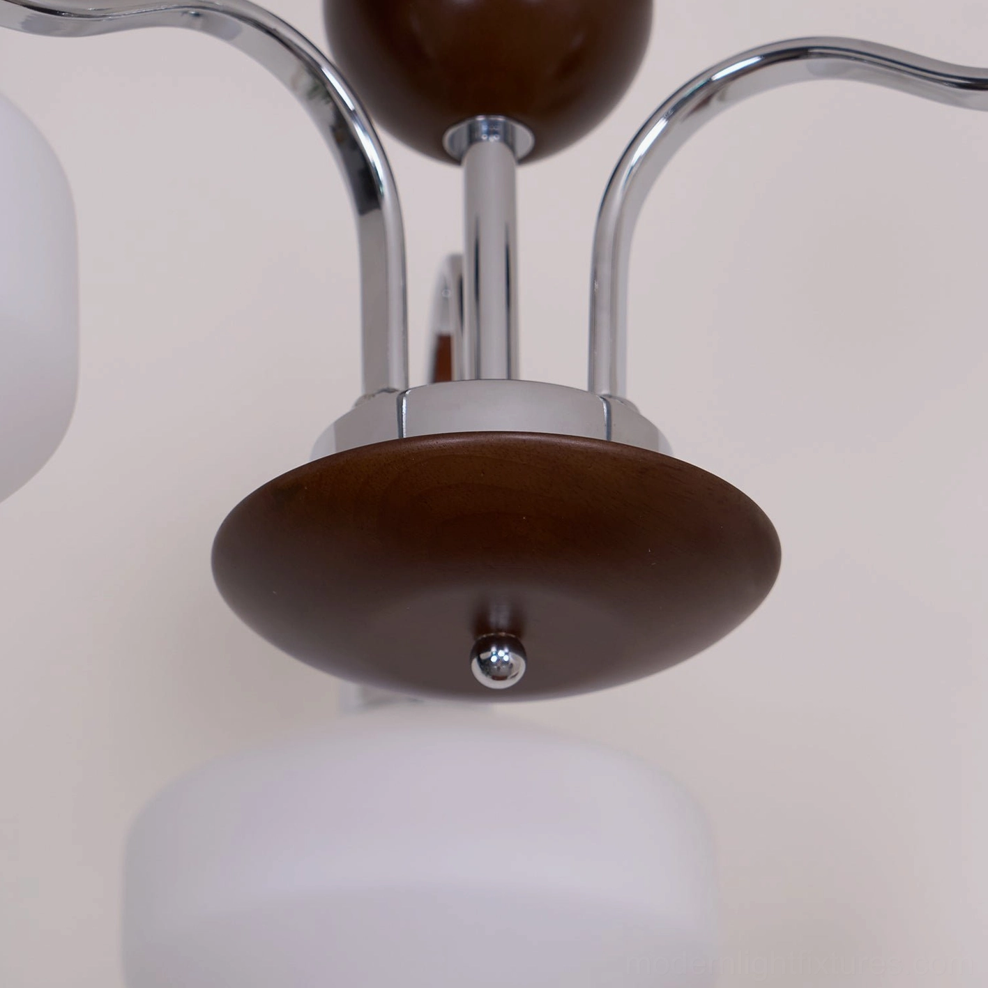 Sputnik chandelier close-up showing frosted white glass shade and chrome arm connection detail