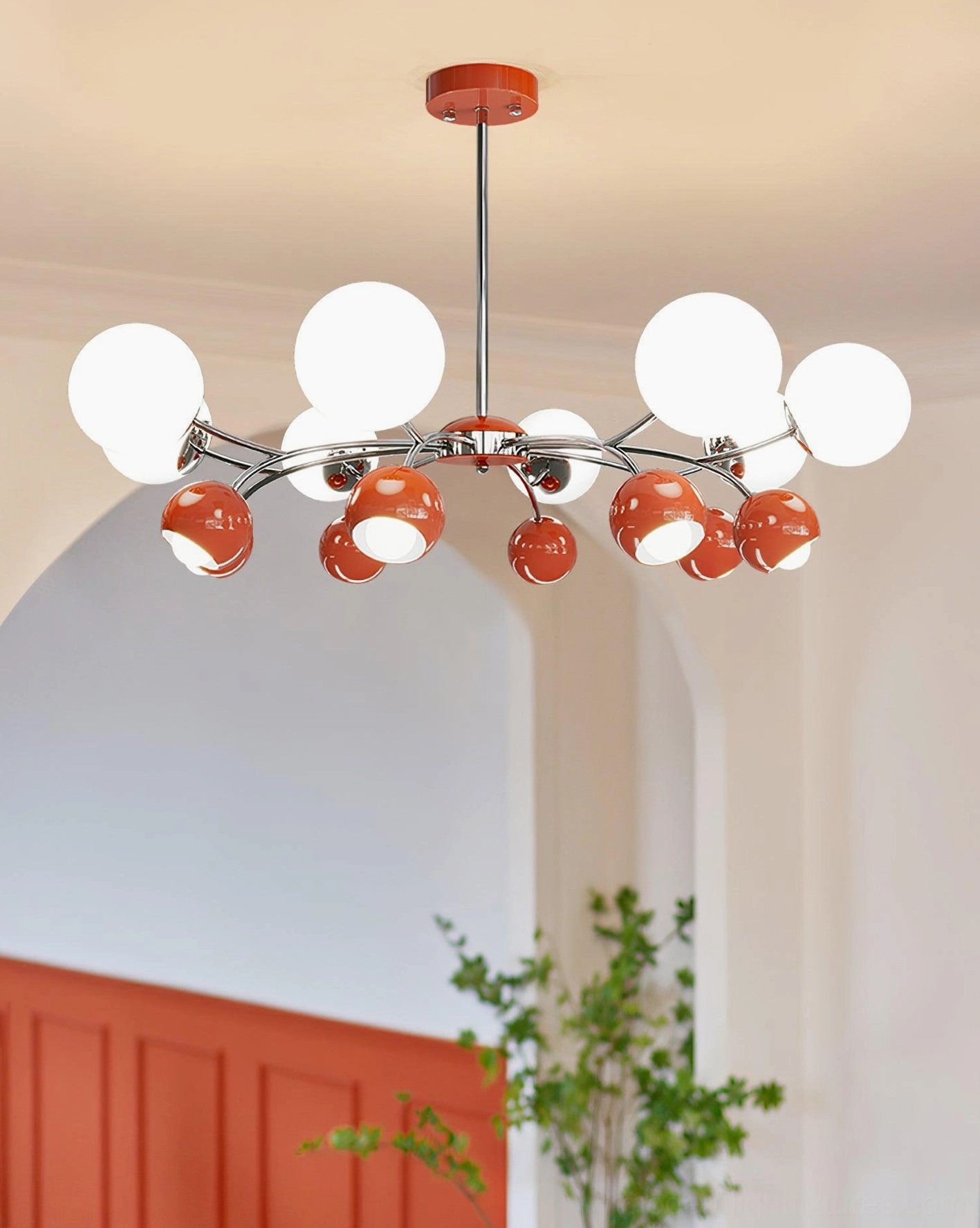 Sputnik pendant chandelier with red accent and white frosted glass globes glowing in living room with orange accent wall