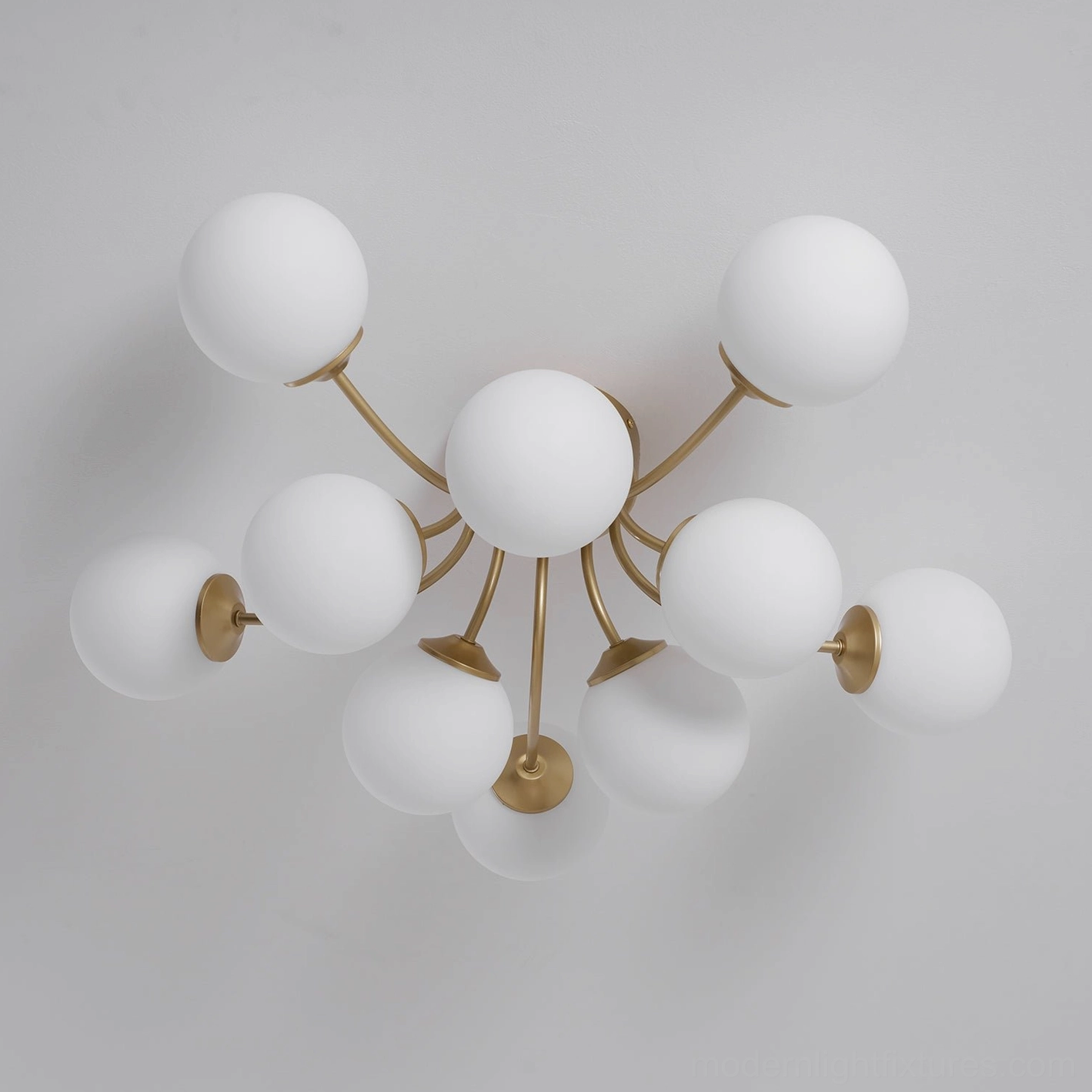 Sputnik ceiling light with frosted glass balls radiating from central brass gold hub