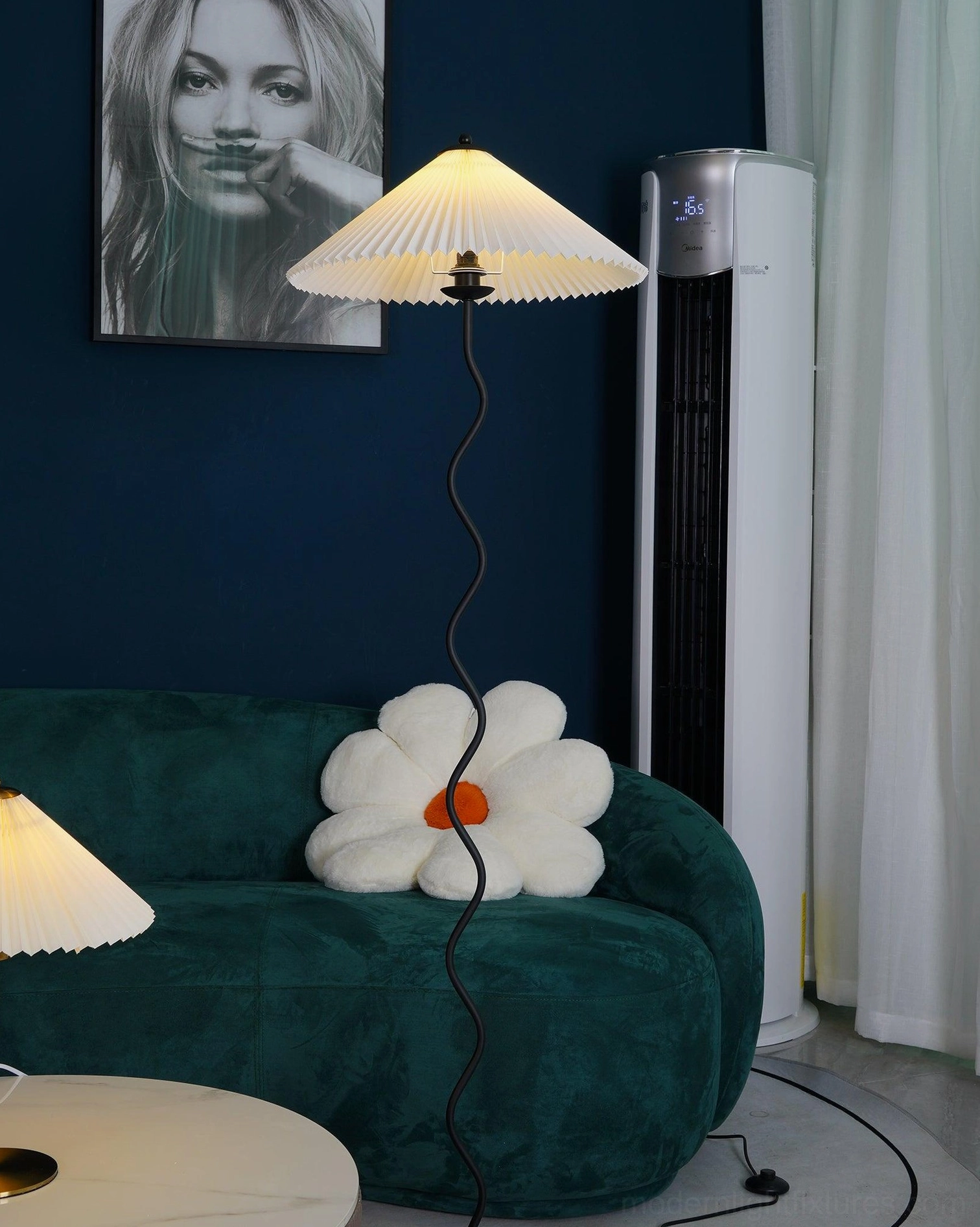 Modern wavy pole floor lamp with warm light in living room with green velvet sofa - artistic sculptural lighting fixture