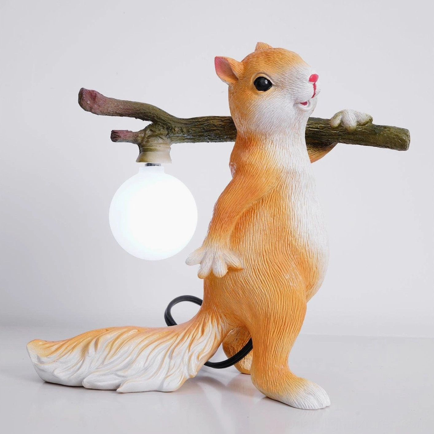 Squirrel table lamp rear view with black power cord against studio background, matte white bulb