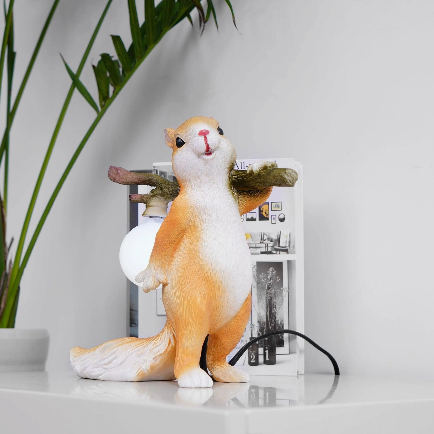 Squirrel table lamp on shelf with potted plant, rear view showing resin texture and frosted glass bulb