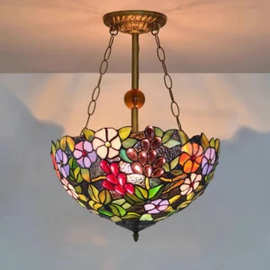 Mixed flower and grape stained glass chandelier hanging from ceiling with warm ambient lighting
