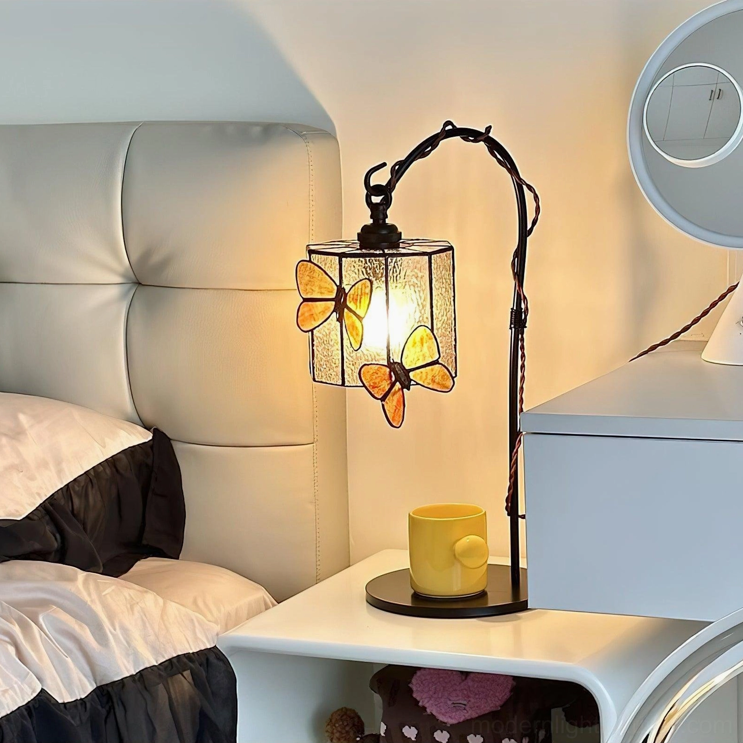 Stained glass butterfly table lamp illuminated on modern bedroom nightstand creating warm ambient lighting