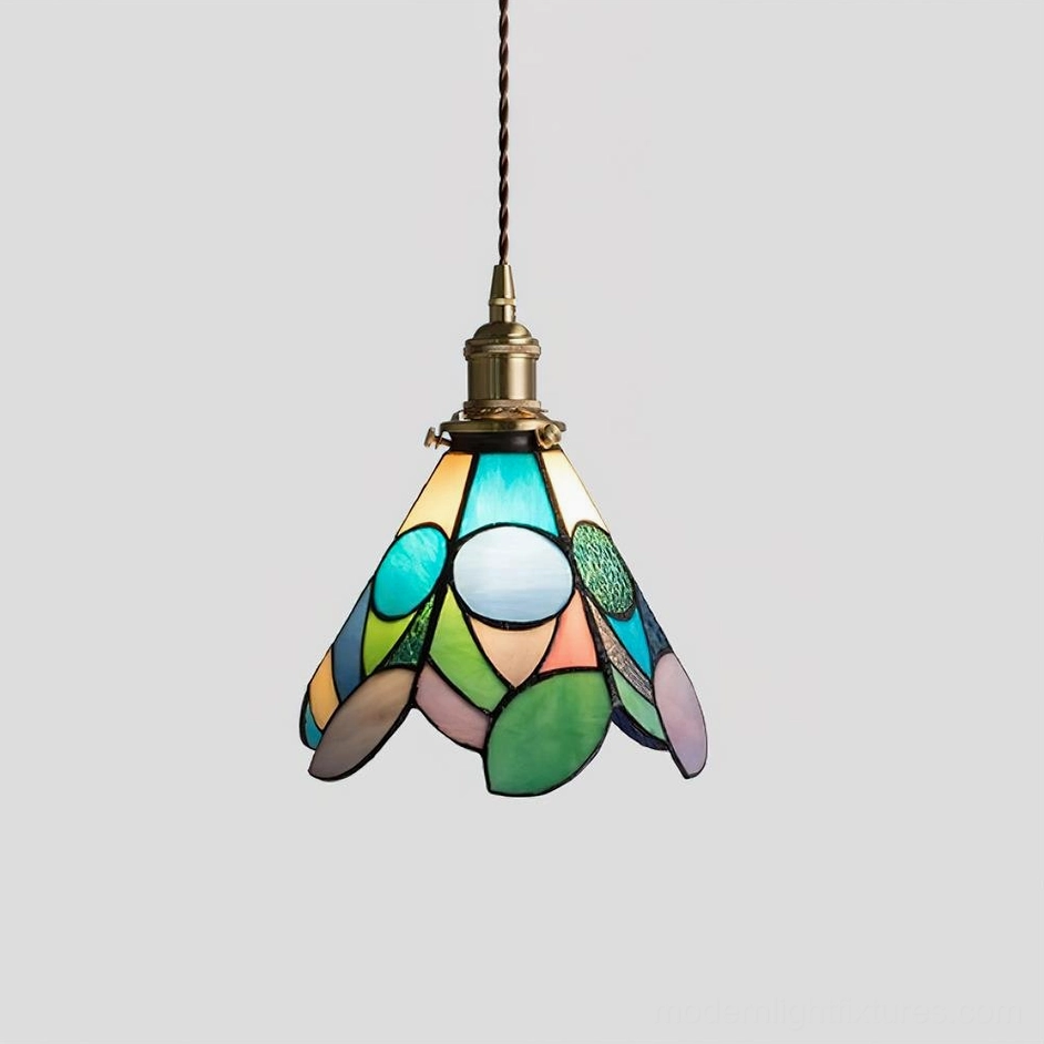 Pendant lamp with stained glass installed in contemporary dining room creating warm ambient lighting