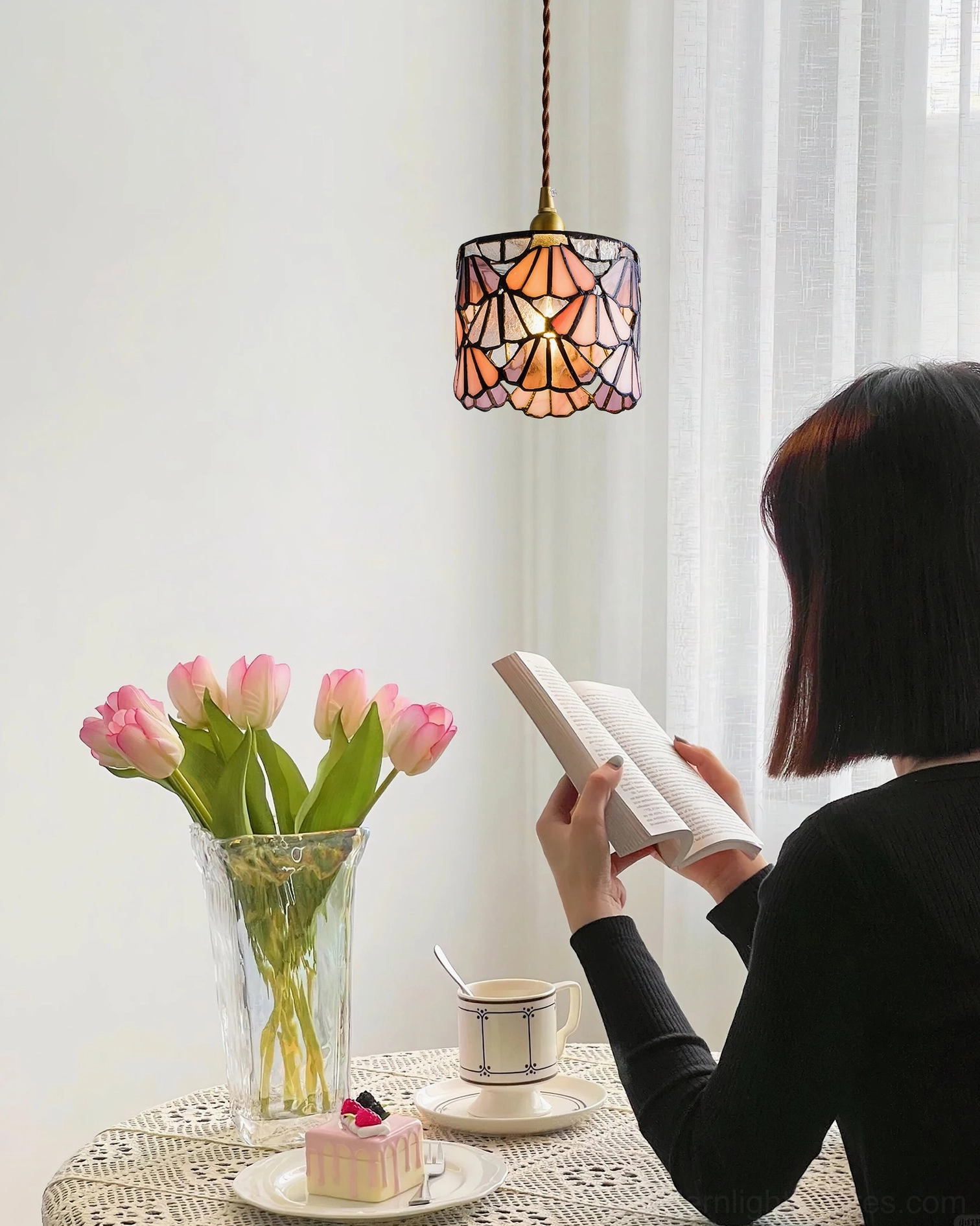 Blue stained glass pendant light casting colored light over afternoon tea dining table, cozy atmosphere