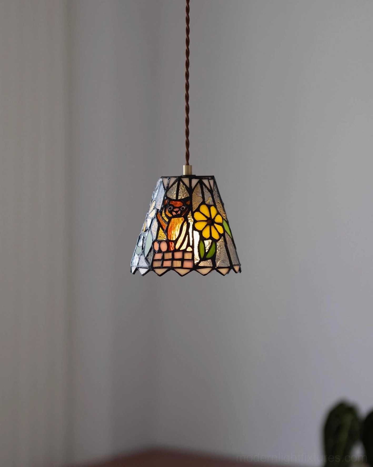 Stained glass pendant light installed in dining room creating intimate gallery-like atmosphere