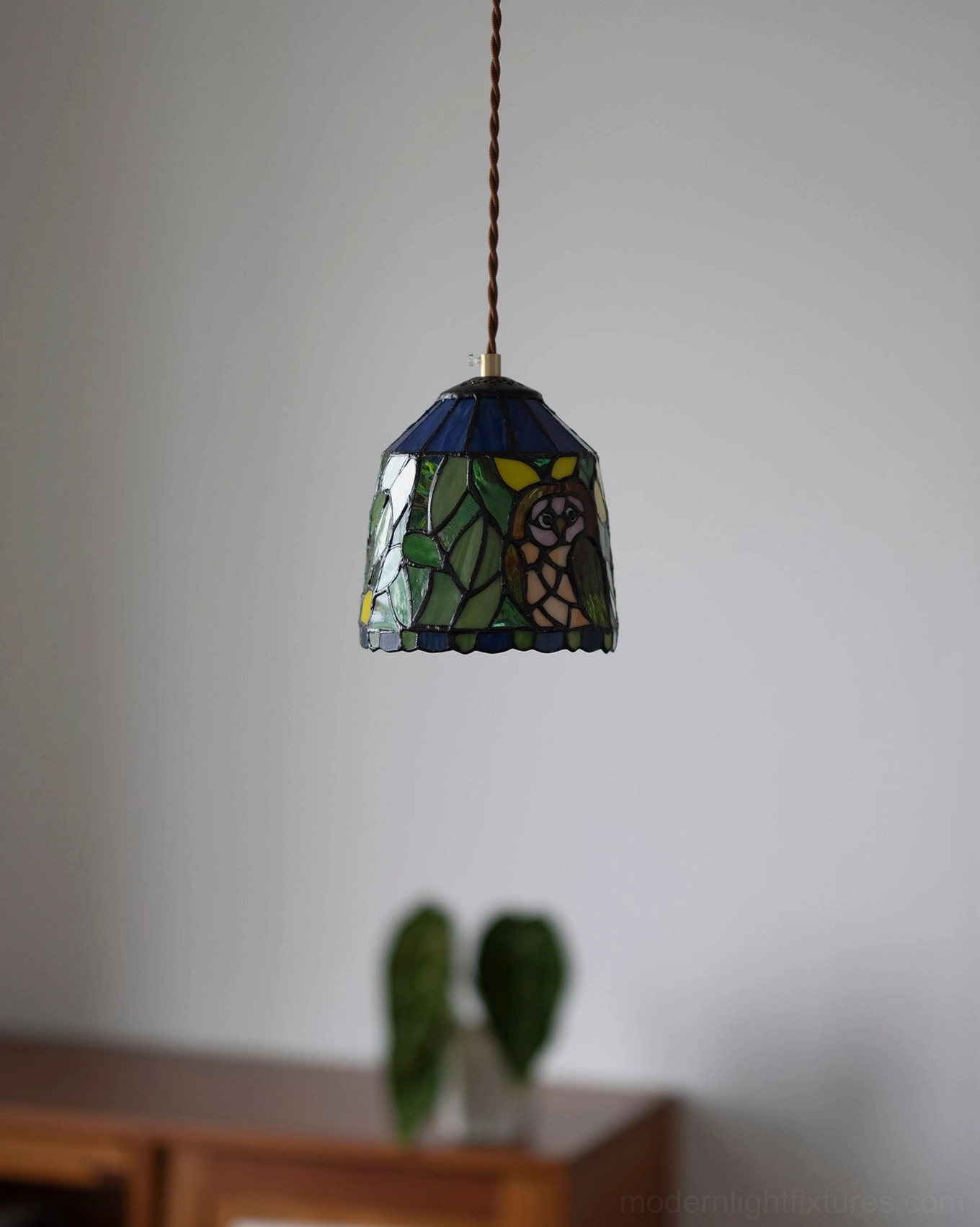 Stained glass pendant lamp in eclectic boho interior with monstera plant and vintage decor