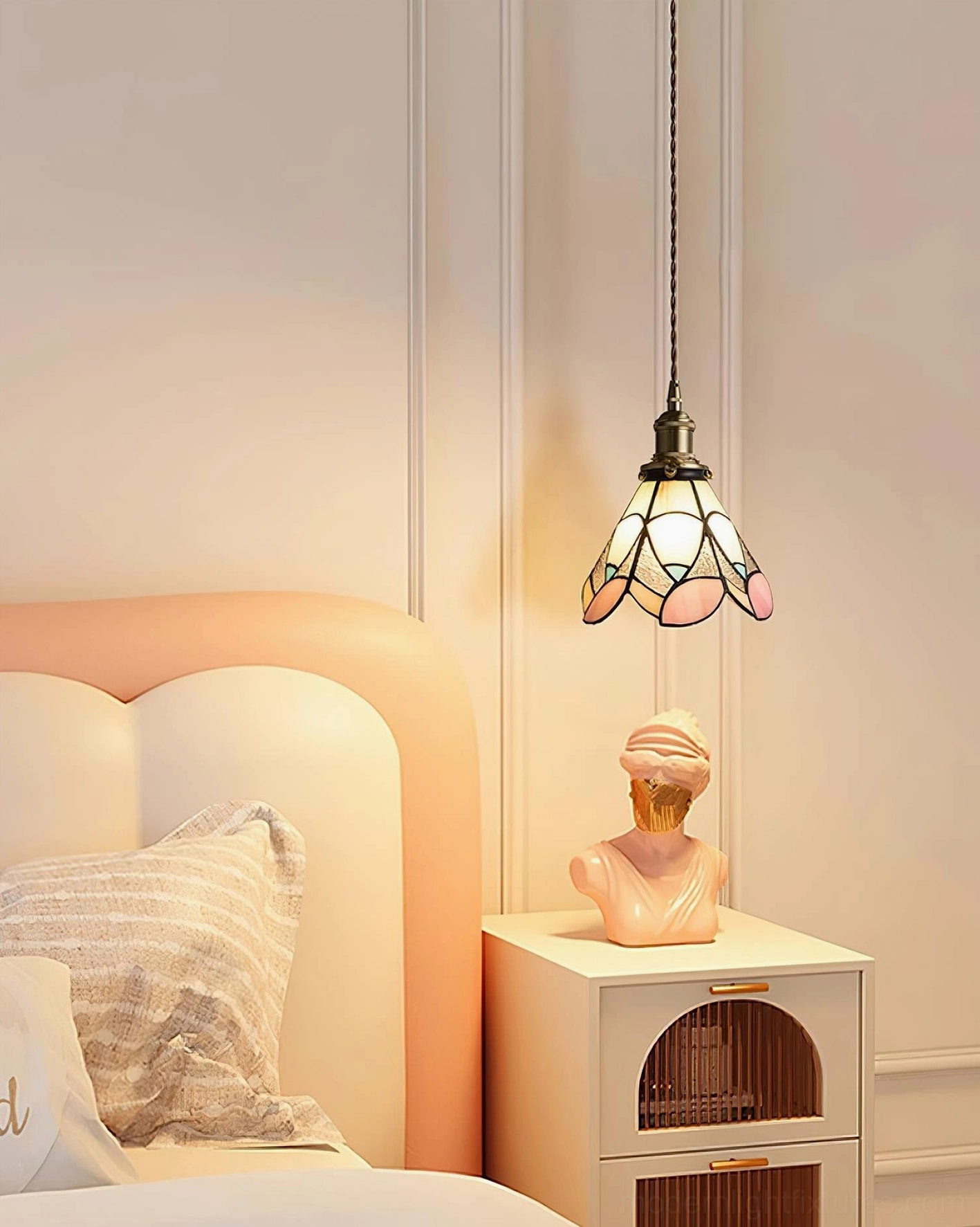 Handcrafted stained glass pendant lamp side view in bedroom setting with warm petal shade casting colored light