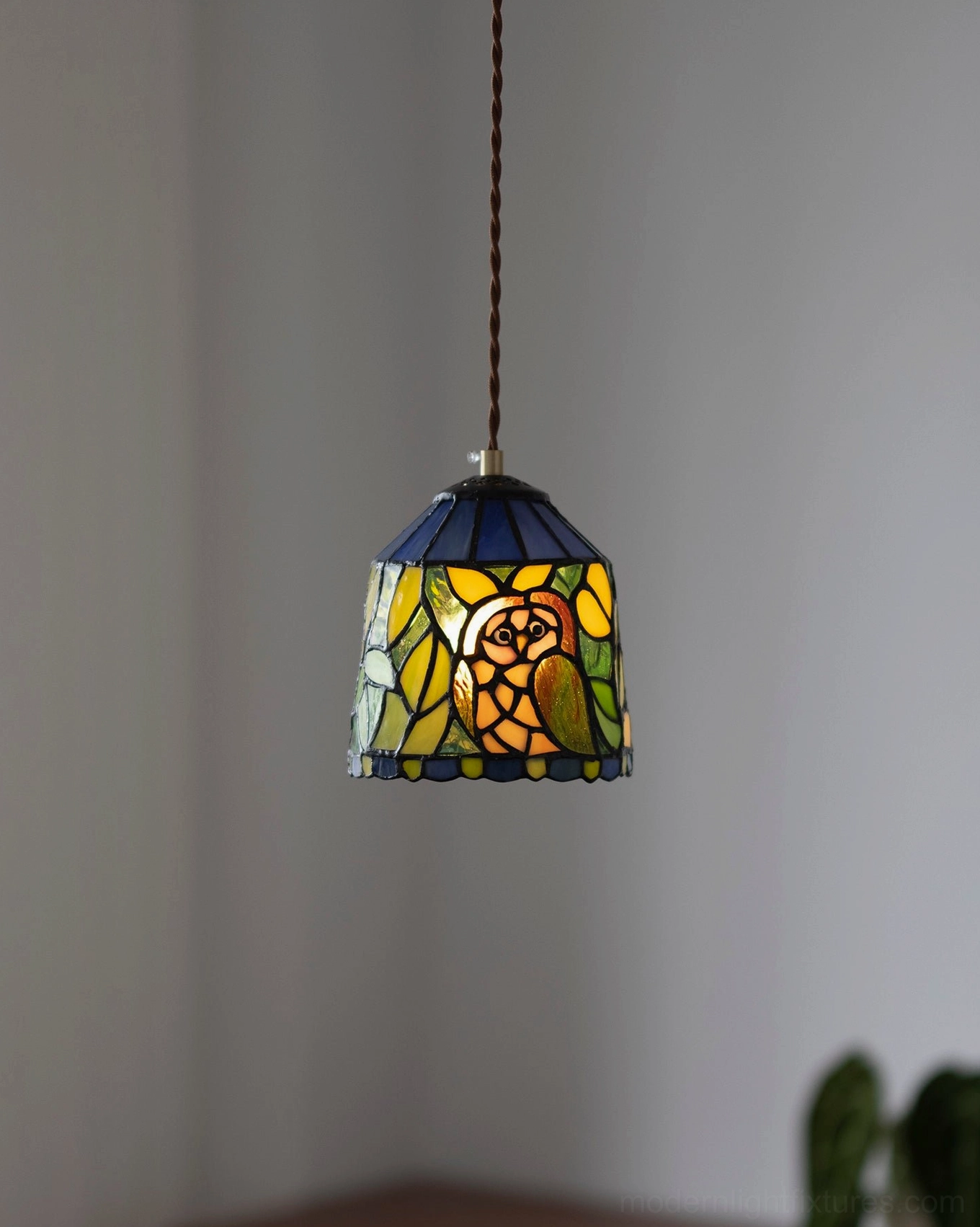 Multiple handcrafted stained glass pendant lamps with varied animal and botanical motifs collection