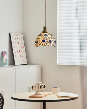 Stained glass daisy pendant lamp with warm blue-yellow glow hanging in Nordic style dining room