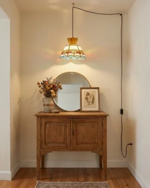 Plug-in stained glass pendant light installed above console table in entryway creating warm multicolor ambient glow with visible copper-foil seams and scalloped art-glass hem