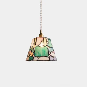 Handcrafted stained glass pendant light with trapezoid shape and mixed colorful glass panels, brass hardware, studio front view