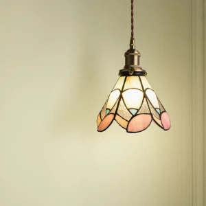 Stained glass pendant light with warm ambient glow, three-quarter angle showing petal glass shade and vintage brass fixtures