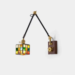 Front studio view of adjustable stained glass swing arm wall sconce featuring multicolor mosaic cube shade, dual black metal swing arms, and walnut wood wall mount - vintage industrial design
