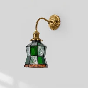 Geometric patchwork stained glass wall lamp with gold brass hardware, front flat view displaying emerald green and clear glass panel design