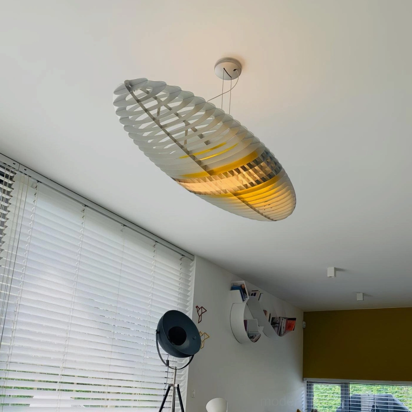 Star Ship pendant light with translucent white and yellow slatted shade in residential room low-angle view