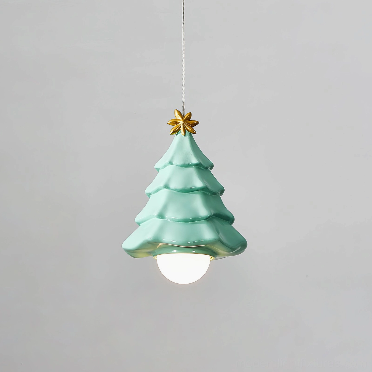 Mint green ceramic Christmas tree pendant light with golden star topper, oblique angle view showcasing sculptural form and glossy finish