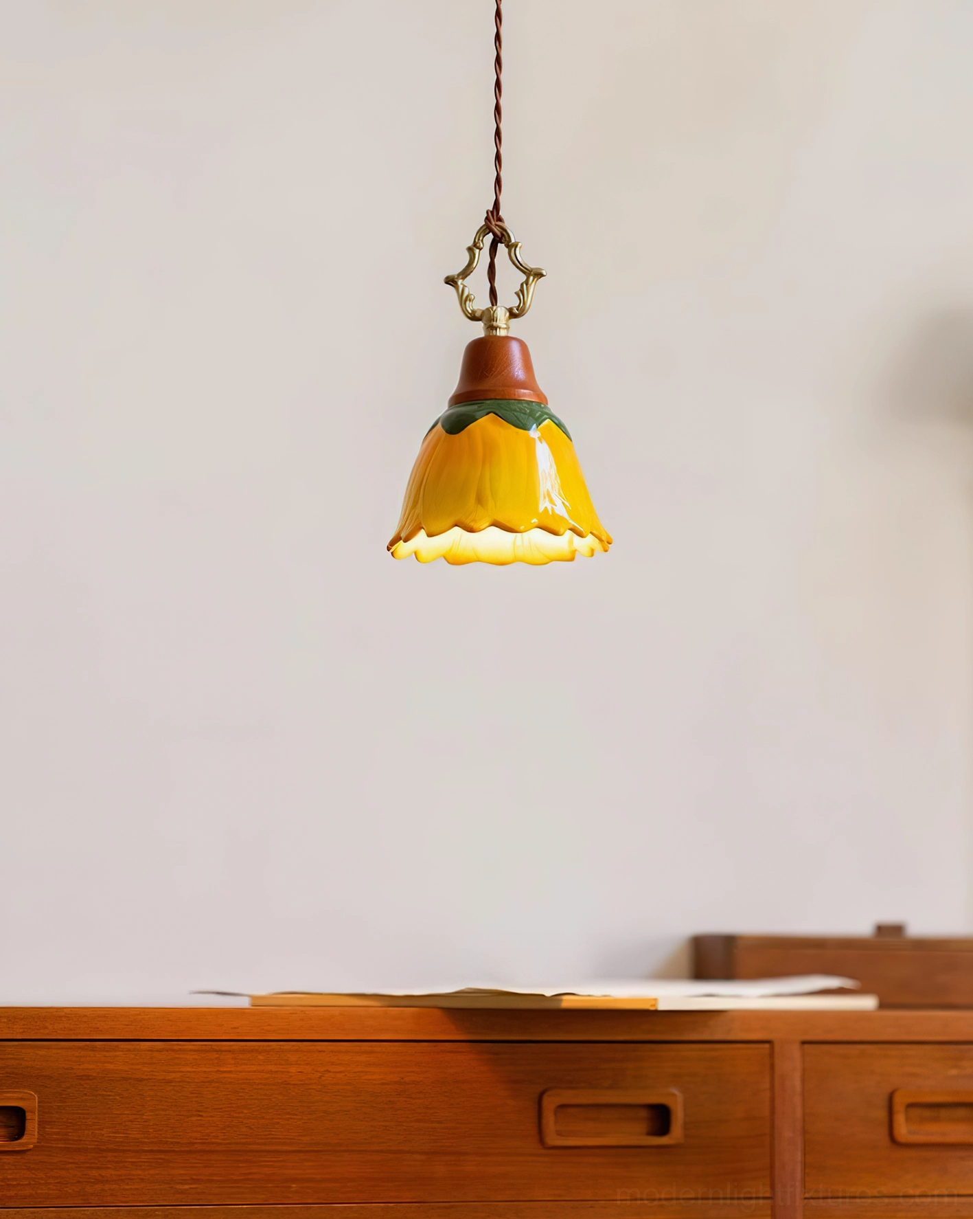 Stella ceramic pendant light displayed in home setting above wooden dresser with vintage accessories