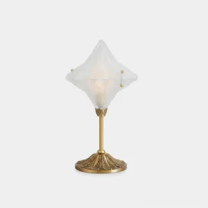 Stellara diamond glass table lamp with brass carved base, frosted geometric shade on white studio background, modern lighting fixture
