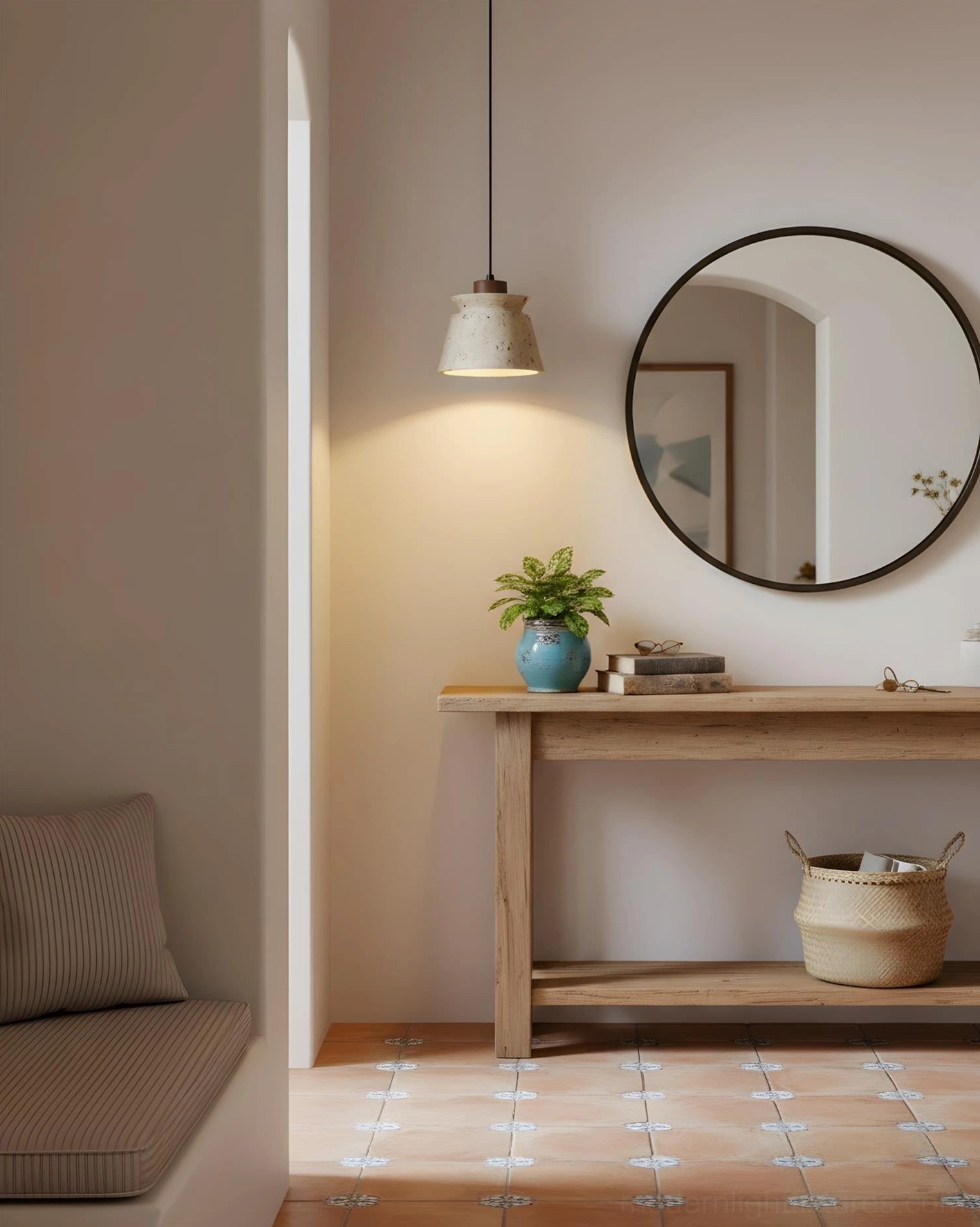 Coastal entryway with neutral travertine pendant light above console table and round wall mirror