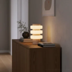 Strata contemporary table lamp positioned on living room side cabinet with potted plant and stacked books, eye-level side view