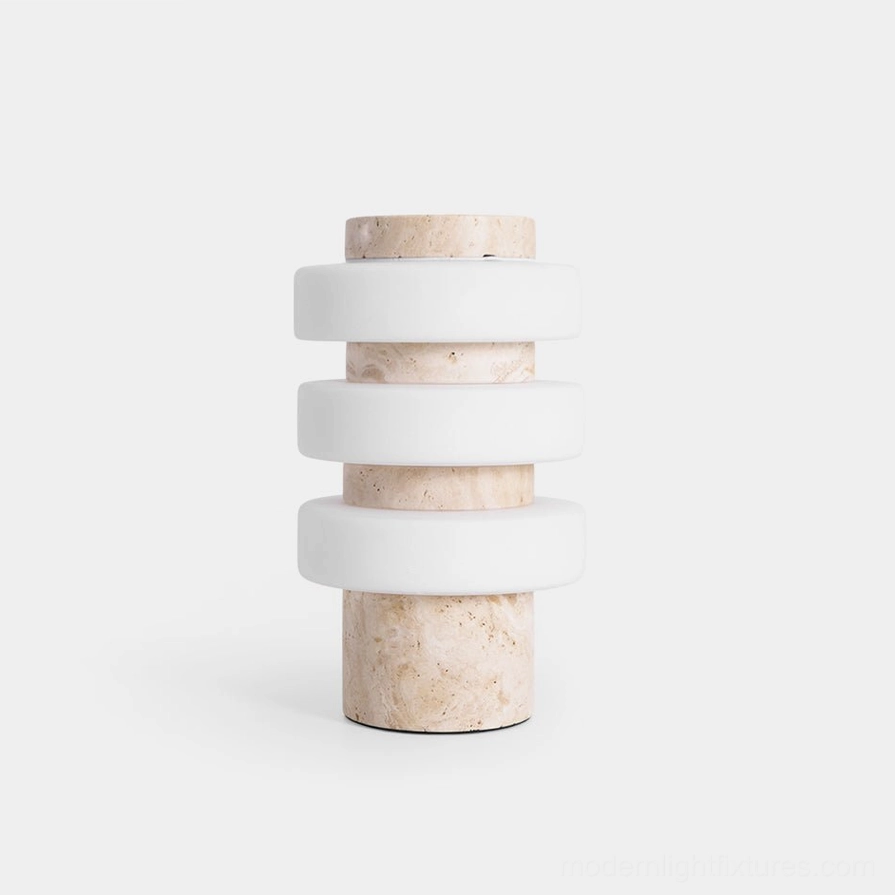 Strata modern table lamp with stacked frosted acrylic rings and travertine base, front studio view showing sculptural LED lighting design