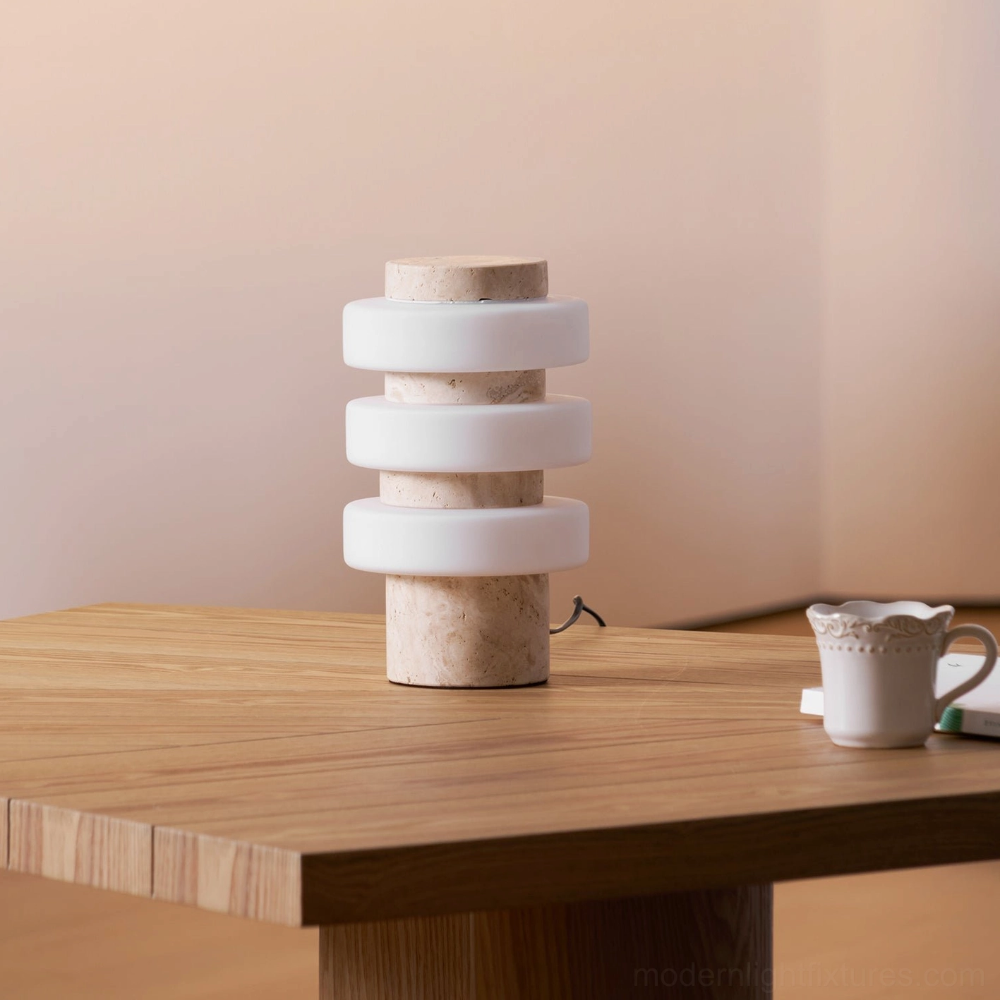 Strata modern table lamp showing stacked rings design from angled perspective with travertine stone base