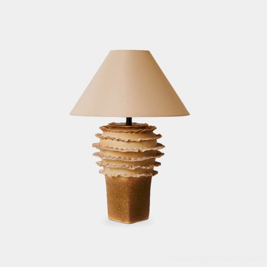 Stratified ceramic table lamp with layered organic base in beige, front view against white background