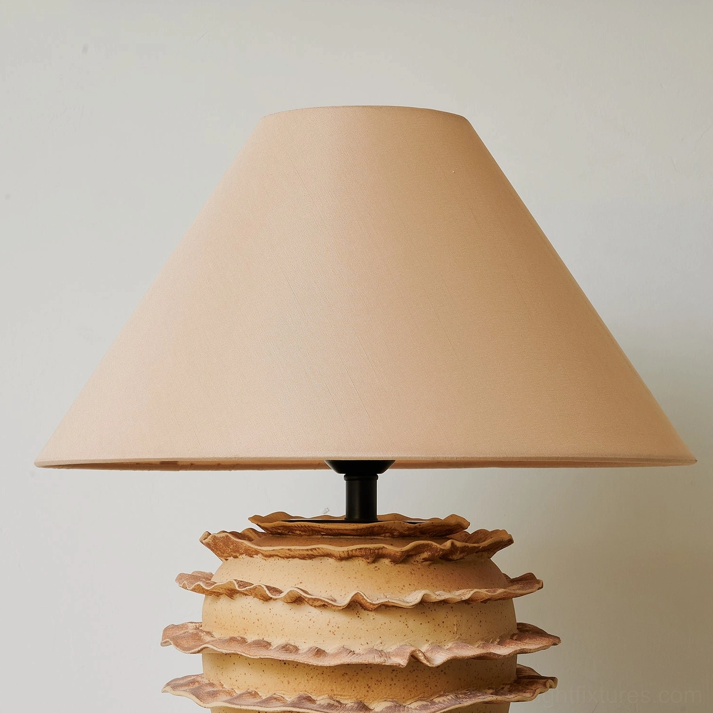 Stratified ceramic table lamp with irregular organic edges and warm textured finish