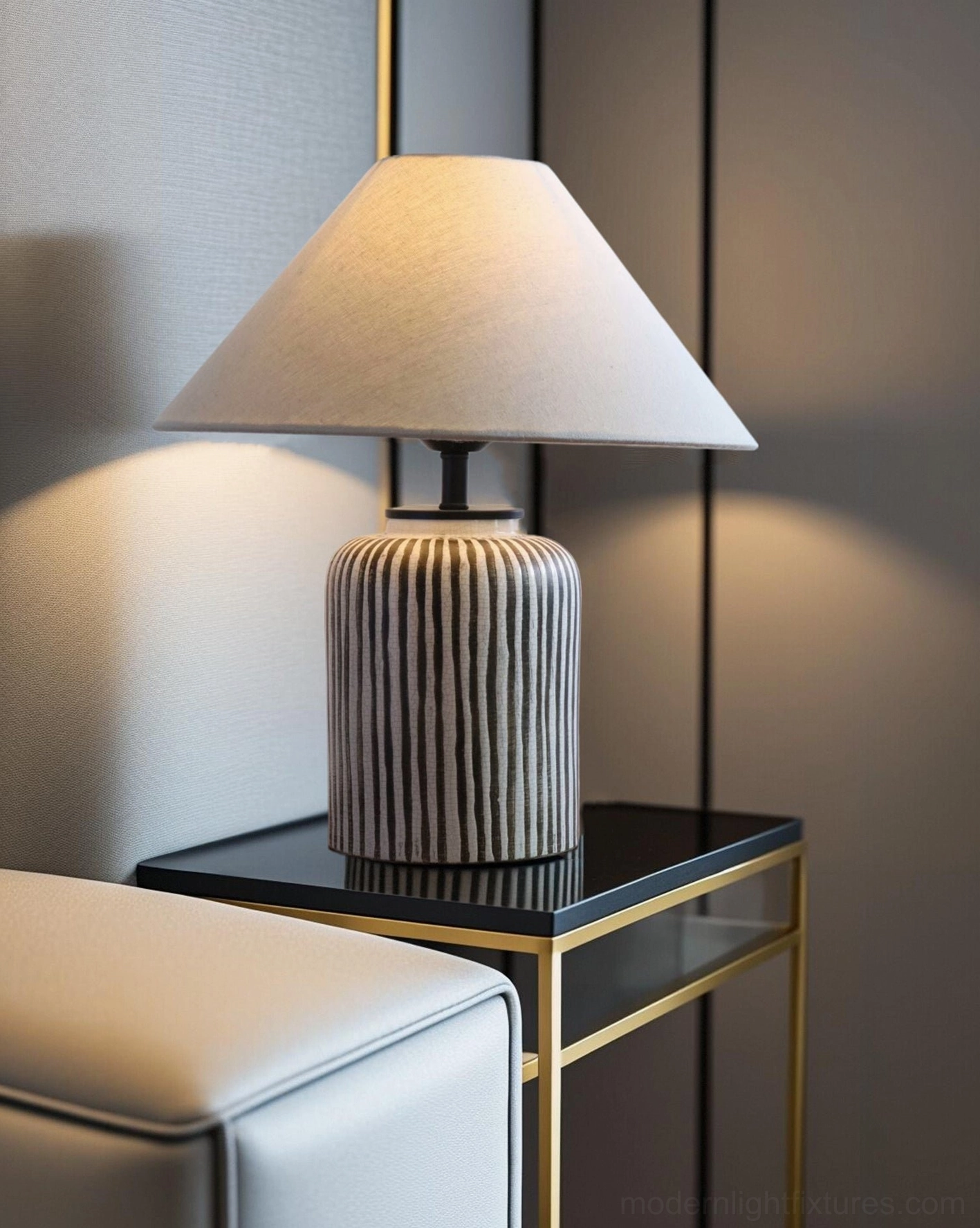 Hand-painted striped table lamp displaying ceramic texture and fabric shade detail in neutral tones