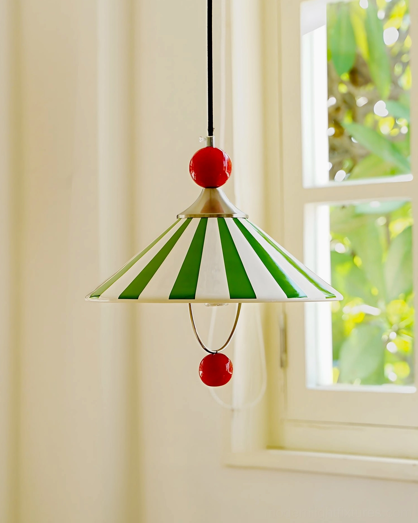 Close-up side view of retro striped pendant lamp by window with sheer curtains, ceramic shade and red accents detail