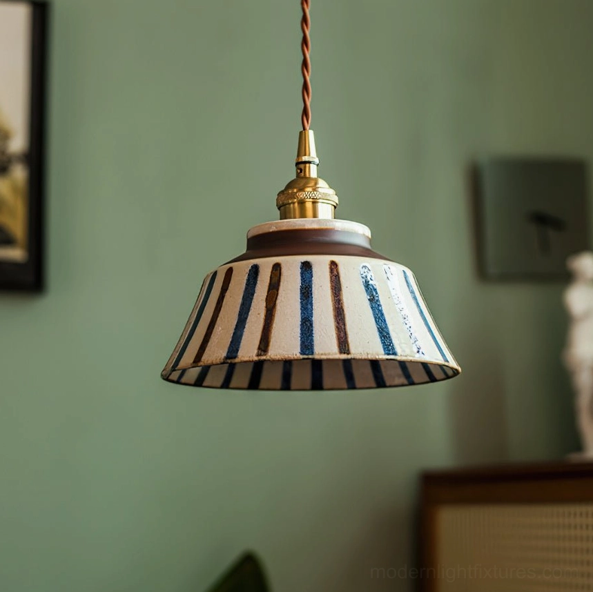 Hand-painted ceramic pendant light with vertical stripe pattern in blue tones, brass fixtures detail