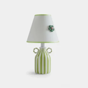 Striped ceramic table lamp with fabric shade and crocheted flower detail, front view on white background