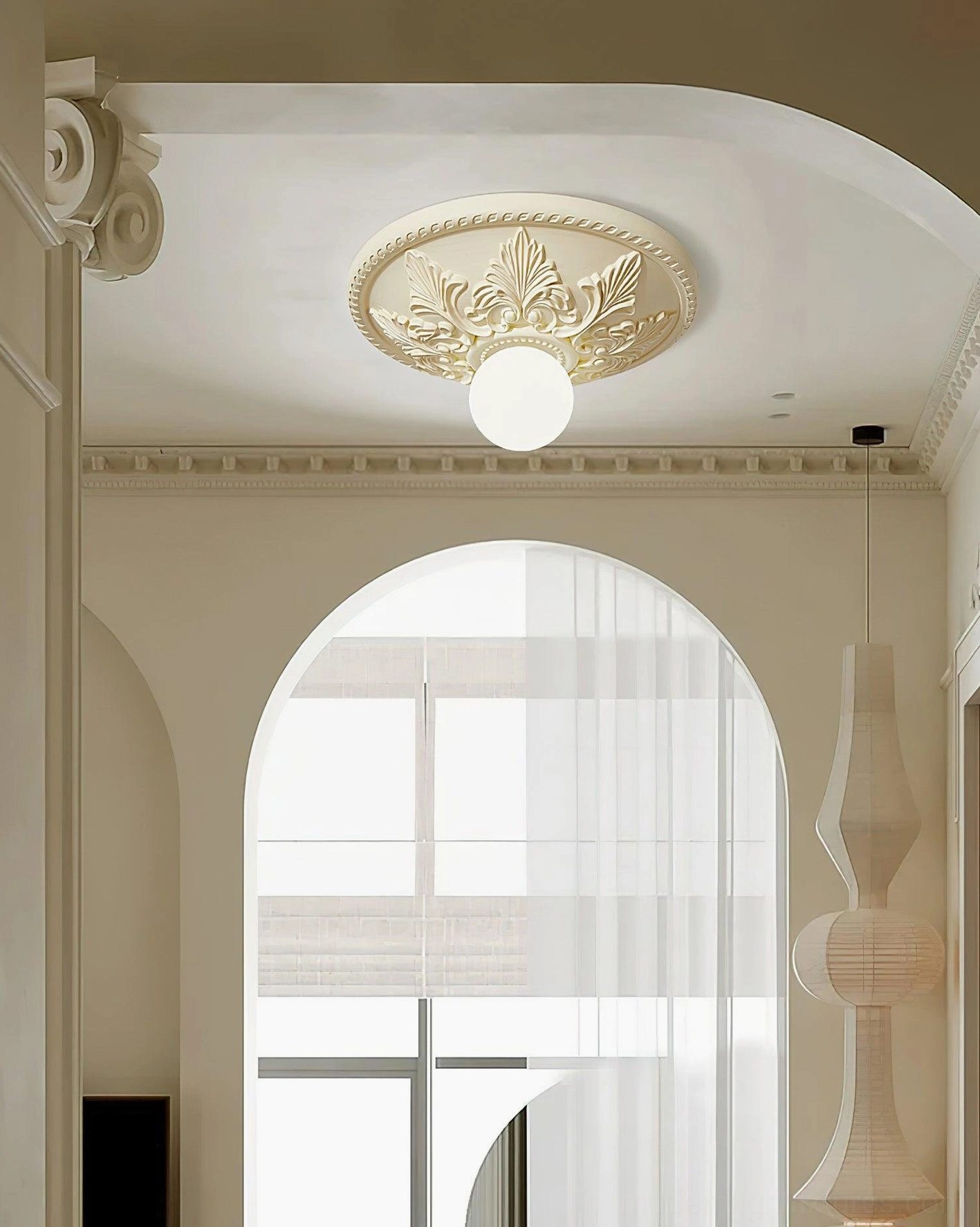 Suilven creamy beige ceiling light with leaf embossed base and warm glowing bulb in arched window living space