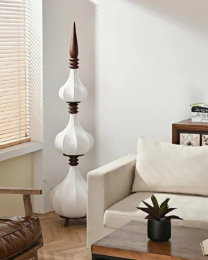 Three-tiered Sultano floor lamp in modern living room setting with walnut wood accents and neutral decor