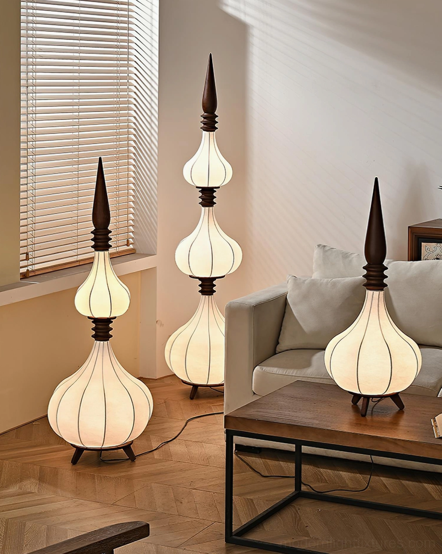 Multiple Sultano gourd floor lamps in various sizes arranged in cozy wooden-floored living space