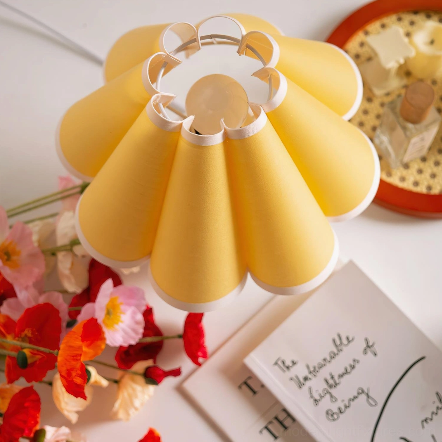 Close-up overhead view of sunburst pleated fabric shade showing yellow color with white trim detail and geometric pleating pattern