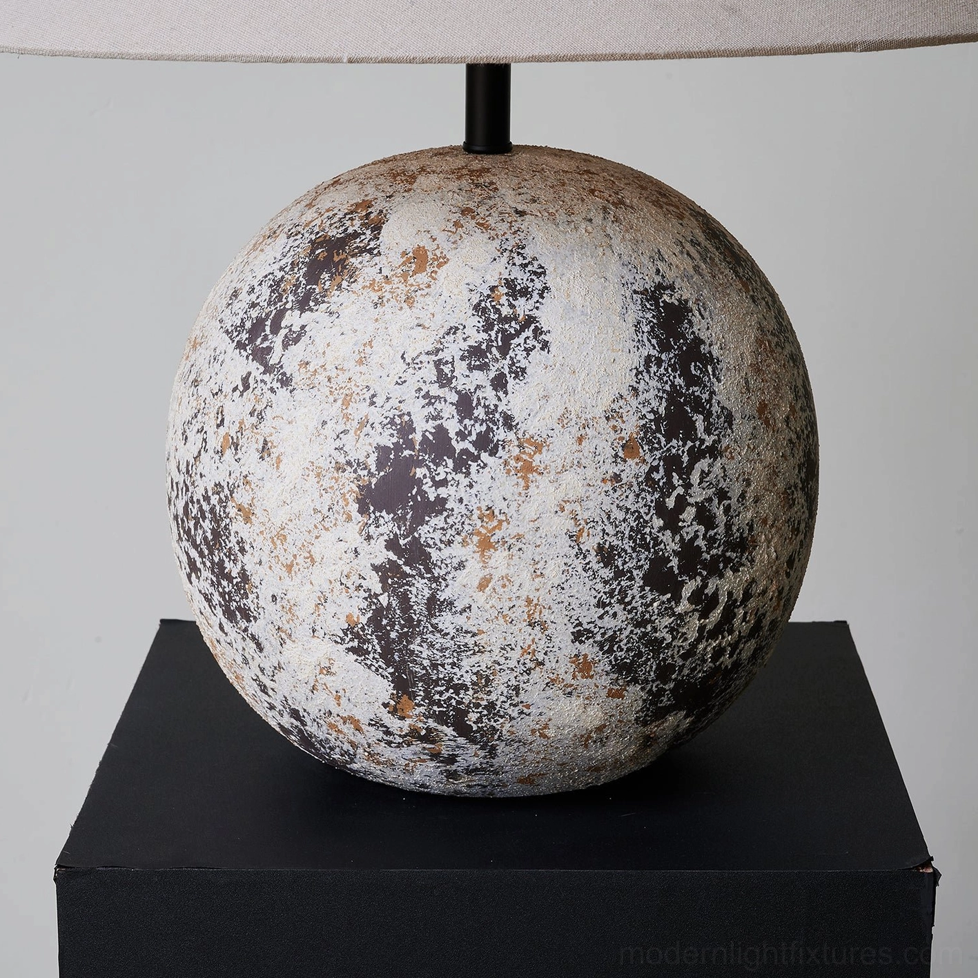 Detailed close-up of Surya ceramic lamp base - low angle shot emphasizing mottled weathered texture on black plinth