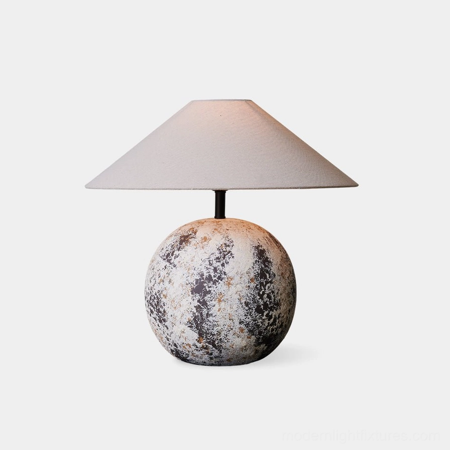 Surya ceramic textured table lamp front view - spherical mottled base with conical beige fabric shade isolated on white background