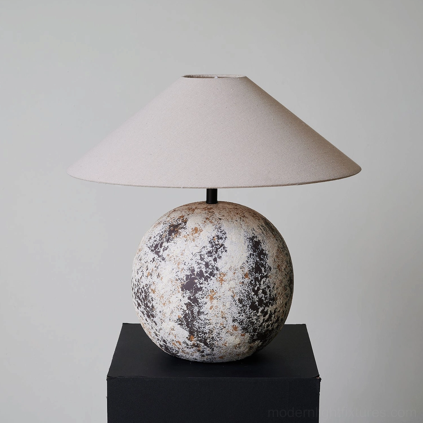 Low front angle view of Surya modern table lamp - complete lamp assembly with spherical ceramic base and fabric shade